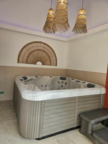 una grande vasca bianca in una stanza con finestra di Les Volets Bleus house and spa a Jublains