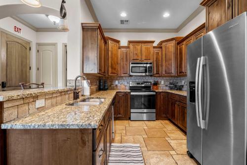 eine Küche mit Holzschränken und einem Edelstahlkühlschrank in der Unterkunft The Overlook at Coral Springs in Harrisburg Junction