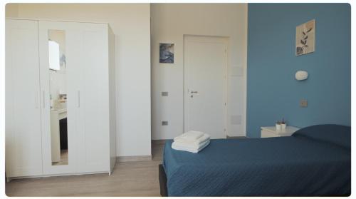 una camera da letto con pareti blu, un letto e uno specchio di Mhometredici Camera doppia Otello a Sestu