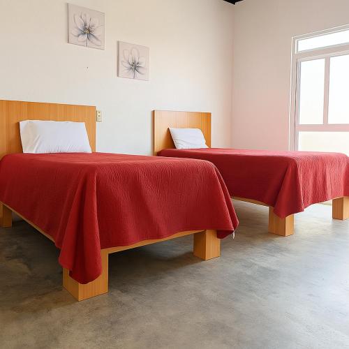 two beds with red blankets in a room at EDISÓN 81 Unidades de renta habitacional in Morelia