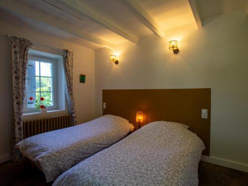 two beds in a bedroom with a window at Maison avec Piscine Privée et Wifi en Dordogne - FR-1-616-501 in Maurens