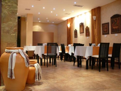 a dining room with white tables and black chairs at Gregorio I Hotel Boutique in San Salvador de Jujuy