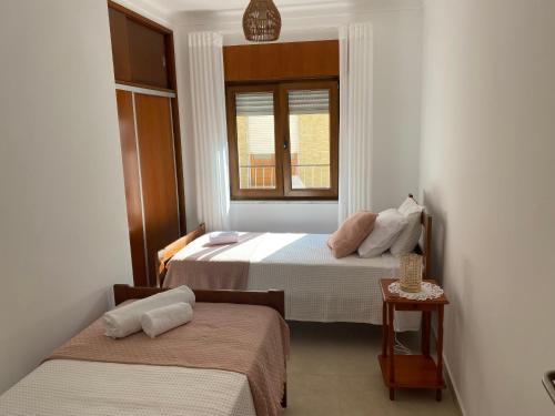 a bedroom with two beds and a window at A Casa da Velha in Alvor