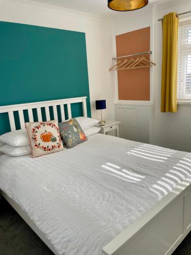 a bedroom with a large bed with a blue wall at Cairo House in Peacehaven