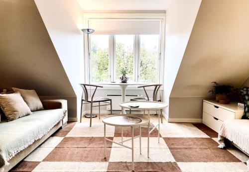 a living room with a table and a window at Refined and Ultra-Central Apartment Studio in Oslo