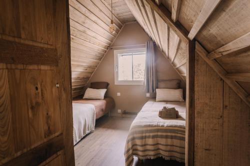 a small bedroom with two beds in a attic at La maison de July in La Roë