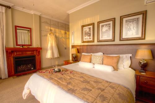 a bedroom with a large bed and a fireplace at Leopardsong Manor in Centurion