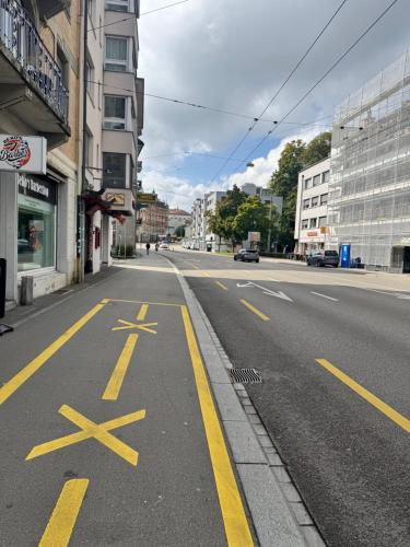 an empty city street with yellow arrows on the road at Apartment im Zentrum St Gallen in St. Gallen