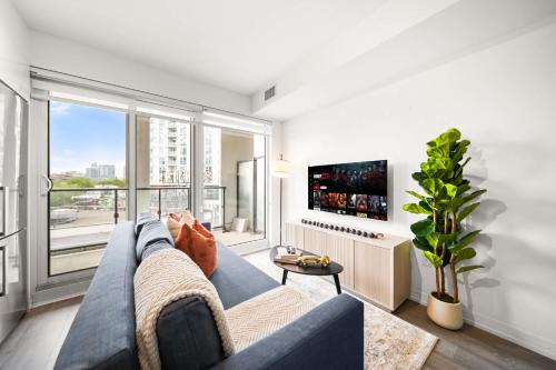 a living room with a blue couch and a large window at City Living Downtown Retreat Perfect Getaway in Toronto