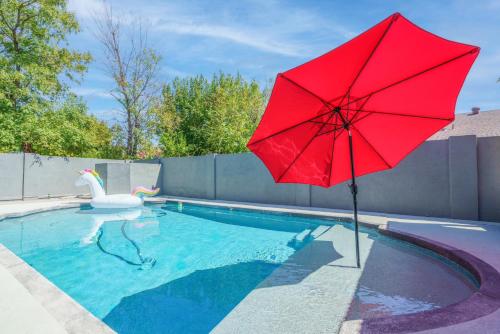 un parasol rouge dans une piscine avec un cygne dans l'établissement New king Beds Pool Hot Tub Outdoor Fireplace, à Lexington Place