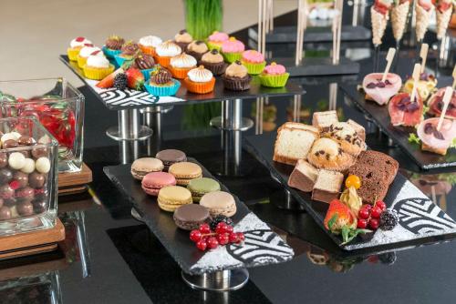 ミュンヘンにあるNH Collection München Bavariaのケーキやペストリーが並ぶテーブル