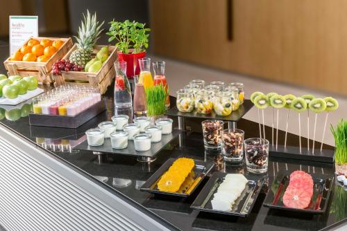 ミュンヘンにあるNH Collection München Bavariaのテーブルの上にさまざまな種類の食べ物が並んだビュッフェ