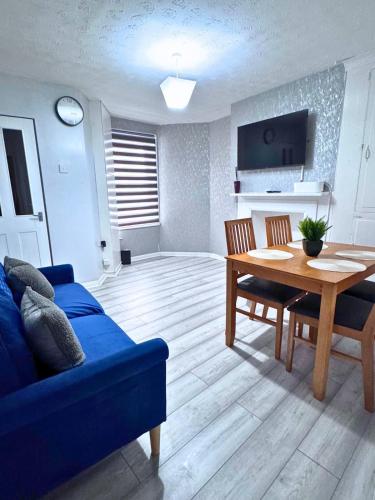 a living room with a blue couch and a table at House for 4 in chatham with free driveway Parking in Chatham