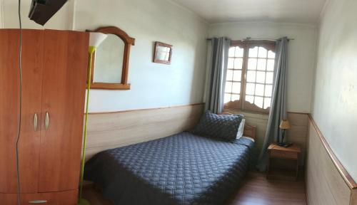 a small bedroom with a bed and a window at Hostal el Parrón in Rancagua
