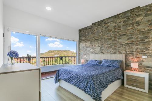 テロルにあるTeror Rural Retreat & Poolのベッドと石の壁のある寝室