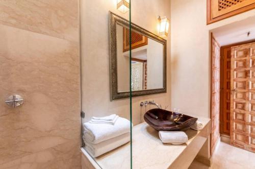 une salle de bain avec un lavabo et un miroir dans l'établissement Riad Kahena, à Marrakech