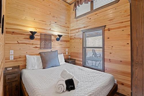 una camera da letto con un letto in una cabina di legno di All Tuckered Out - Riverfront Cabin, Fish, Hike & 5 Minutes to Sylva! a Sylva