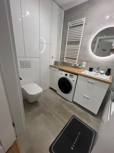 a bathroom with a washing machine and a toilet at Zakrzówek Apartament z Jacuzzi in Krakow
