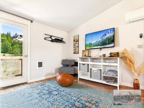 a living room with a tv on a wall at PNW Scenic Loft with Kitchenette in Philomath
