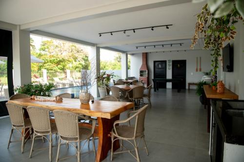 een eetkamer met een houten tafel en stoelen bij Apto com Piscina e Churrasqueira Perto da Praia in São Bento