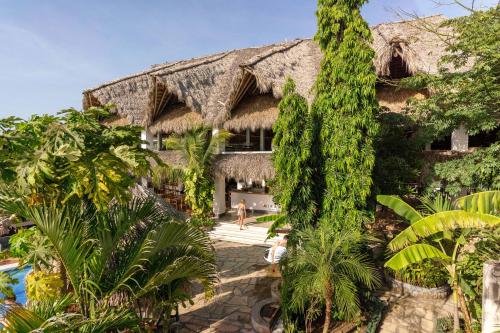 una vista exterior de un complejo con árboles en Miramar SurfCamp, en Puerto Sandino