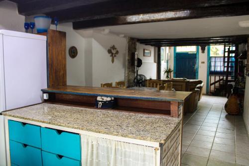 a kitchen with a counter top and a refrigerator at Suítes no Centro Histórico de Paraty in Paraty