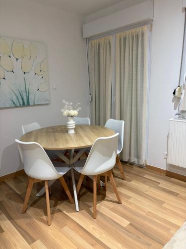 une salle à manger avec une table en bois et des chaises blanches dans l'établissement LairPure, à Villé