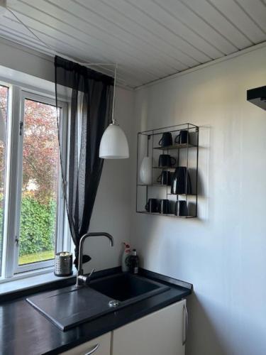 a kitchen with a sink and a window at Motel Villa Søndervang 3 personers værelse in Harndrup