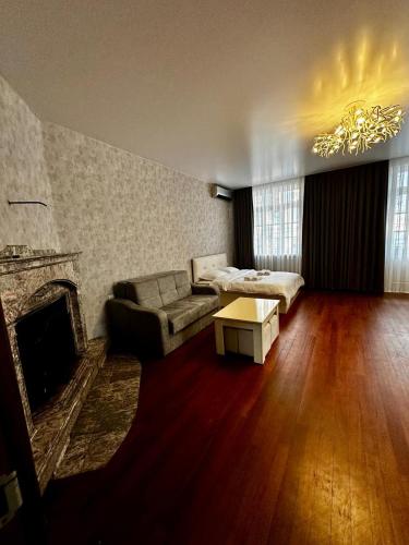 a living room with a couch and a fireplace at Old Boulevard Guest House in Batumi