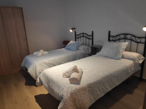 Dos camas con toallas en una habitación. en Paco del Molino 2, en Grazalema