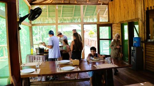 un grupo de personas de pie alrededor de una mesa en una cocina en Paroá Amazon Lodge, en Manacapuru