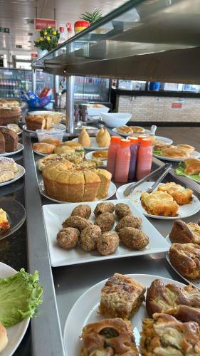 ein Buffet mit verschiedenen Speisen auf Platten in der Unterkunft Hotel Via Montes in Montes Claros