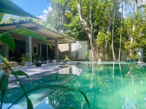 a house with a swimming pool with a house at Monkey Banana Villa in Galle