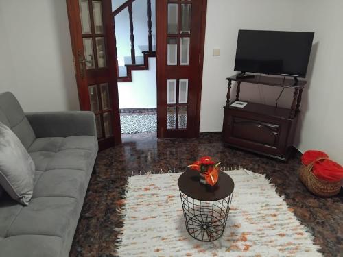 ein Wohnzimmer mit Sofa und Fernseher in der Unterkunft Refugio Catanho in São Vicente