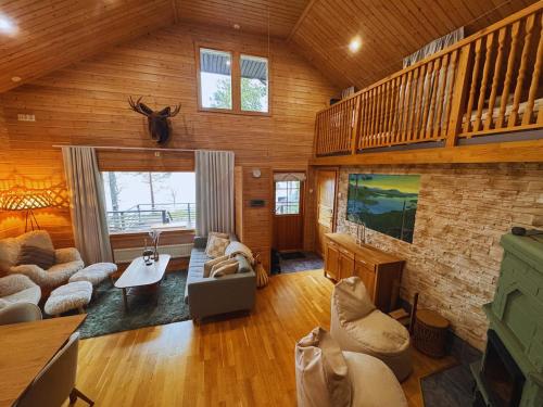 a large living room with wooden walls and wooden floors at Cozy Arctic Lakeside Cottage with private sauna in Pello