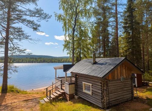 a cabin on the shore of a lake at Cozy Arctic Lakeside Cottage with private sauna in Pello