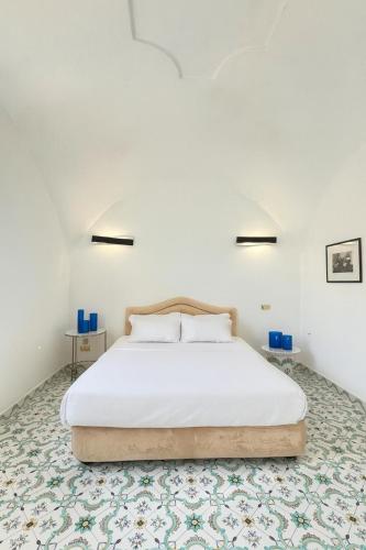 a bedroom with a white bed and a patterned floor at Valentino in Capri