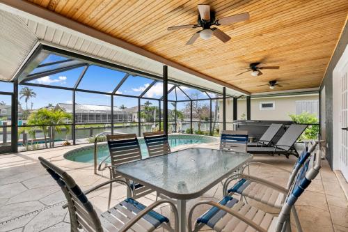 Marco IslandにあるWaterfront Island Mirrorageのテーブルと椅子とプールのあるパティオ