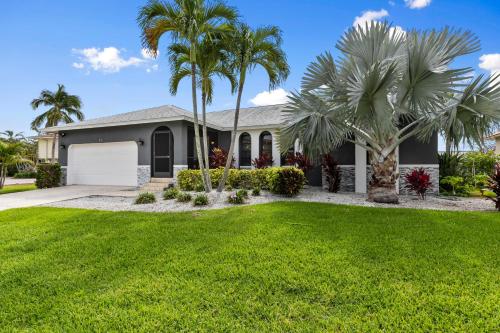 Marco IslandにあるWaterfront Island Mirrorageの庭前のヤシの木がある家