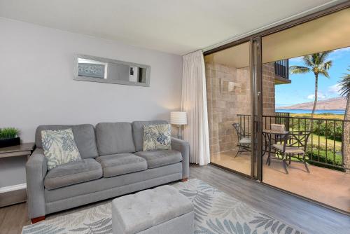 a living room with a couch and a balcony at Kauhale Makai 212 in Kihei