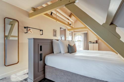 a bedroom with a large white bed in a attic at Metzlr House in Haarlem