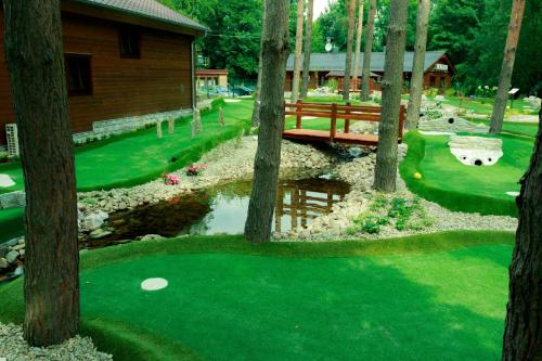 a golf course with a bridge and a pond and trees at An-Son Apartamenty in Zielona Góra