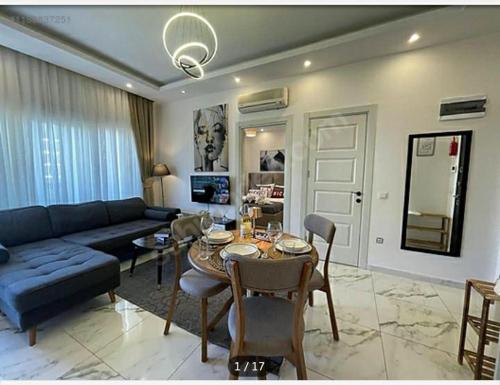 a living room with a table and a blue couch at Kestel City in Alanya