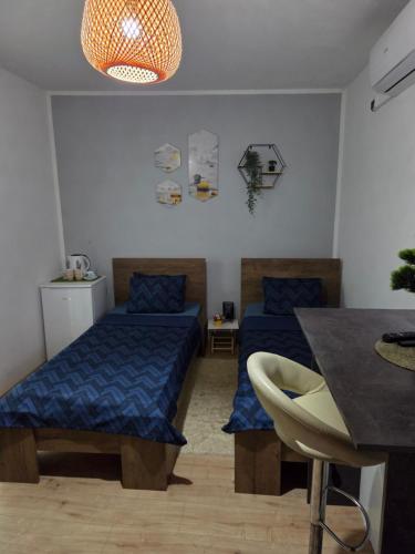 a room with two beds and a dining table at Zen 6 deluxe room in Zrenjanin