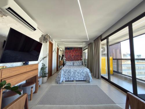 ein Schlafzimmer mit Bett und Flachbildfernseher in der Unterkunft Studio luxo na Barra in Salvador
