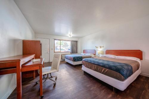 a bedroom with two beds and a desk and a desk at Hotel O Rama Inn & RV Park in Washougal