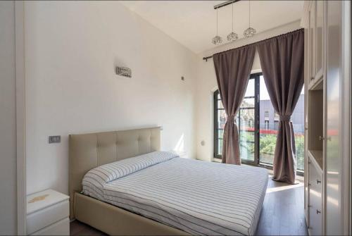 サヴォーナにあるCasa Adrianaのベッドルーム1室(ベッド1台、大きな窓付)