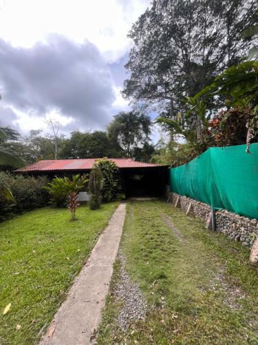 Un camino que conduce a un edificio con una lona verde. en Cocles House, en Talamanca