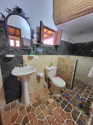 a bathroom with a sink and a toilet and a mirror at AQUI ESTOY BIEN in Barichara