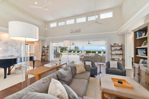Una sala de estar con un sofá y un piano. en Luxury Retreat in Kona with Saltwater Pool, en Kailua-Kona